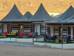 a building with purple and pink chairs in front of it at Bubble Sofia Luxury Rum Camp in Wadi Rum