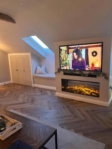 sala de estar con chimenea y TV de pantalla plana en Kiln House Lodge, en Harrogate