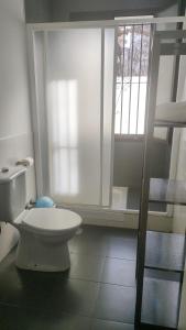 een witte badkamer met een toilet en een raam bij Arce apartamentos in Sevilla