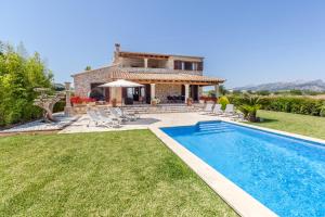 a villa with a swimming pool in front of a house at Villa Guillona in Alcudia