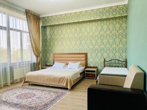 1 dormitorio con 2 camas y ventana grande en Dostyk en Kyzylorda