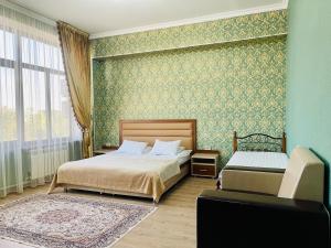 a bedroom with two beds and a large window at Dostyk in Qyzylorda