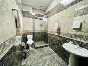 a bathroom with a shower and a toilet and a sink at Dostyk in Qyzylorda
