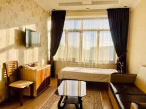 克孜勒奧爾達的住宿－Dostyk，一间卧室配有一张床、一张沙发和一个窗口