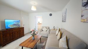 uma sala de estar com um sofá e uma televisão em Peaceful Lawley Home 3 Bedrooms with Parking, Garden, Wi-Fi em Lawley Bank