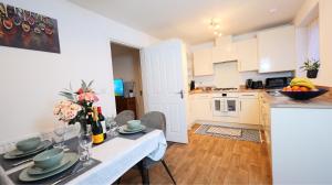 una cocina con una mesa con un jarrón de flores. en Peaceful Lawley Home 3 Bedrooms with Parking, Garden, Wi-Fi en Lawley Bank