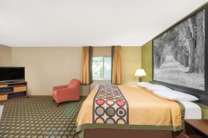 um quarto de hotel com uma cama e uma televisão em Super 8 by Wyndham Olney em Olney