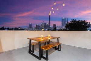 a table on a rooftop with a view of a city at Metro Horizon by AvantStay Rooftop Deck City View in Los Angeles