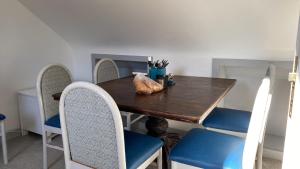 mesa de comedor con sillas azules y mesa de madera en Drop Anchor House, Spacious 3 bedroom apartment, fabulous sea views, en Cleggan