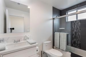 a bathroom with a toilet and a sink and a mirror at Metro Horizon by AvantStay Rooftop Deck City View in Los Angeles