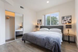 a bedroom with a large bed and a large mirror at Metro Horizon by AvantStay Rooftop Deck City View in Los Angeles