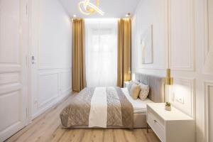 ein weißes Schlafzimmer mit einem Bett und einem Fenster in der Unterkunft Exclusive & Prestigious Central Residence w/ Balcony in Budapest