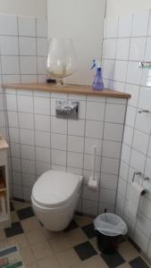 a bathroom with a white toilet and a sink at Hvil og Sov. in Grindsted