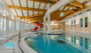 - une grande piscine avec des chaises dans un bâtiment dans l'établissement Hotel Běhounek, à Jáchymov