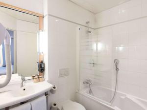 a bathroom with a shower and a toilet and a sink at ibis Paris Opera La Fayette in Paris