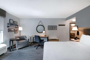 a hotel room with a bed and a desk and a mirror at Hampton Inn Anderson/Alliance Business Park in Anderson