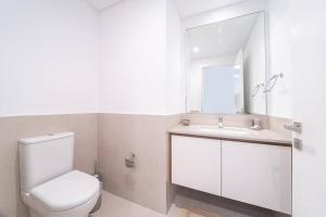 y baño con aseo, lavabo y espejo. en Luxurious 3 BR with Maid Room in Arabian Ranches 2 en Dubái
