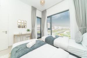 2 camas en un dormitorio con ventana grande en Luxurious 3 BR with Maid Room in Arabian Ranches 2 en Dubái