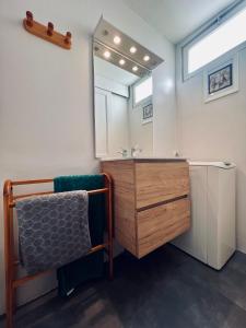 La salle de bains est pourvue d'un lavabo et d'un miroir. dans l'établissement Boudin Cottage Honfleur, à Honfleur