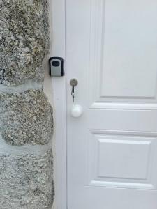 a white door with a lock on a stone wall at Cottage Aldeia Da Serra - historic areas of Portugal in Celorico da Beira