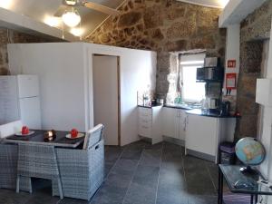 a kitchen with white cabinets and a table at Cottage Aldeia Da Serra - historic areas of Portugal in Celorico da Beira