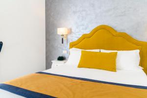 a bedroom with a large bed with a yellow headboard at Amalfi Luxury House in Amalfi