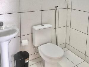 a bathroom with a white toilet and a sink at Pousada B3M in Itarema