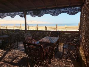 un patio con mesas y sillas y vistas a la playa en Sunset Camp, en Dār as Salām