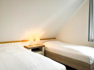 Habitación pequeña con 2 camas y mesa con 2 lámparas. en Feriendorf Papillon Wohnung 03-5, en Boltenhagen