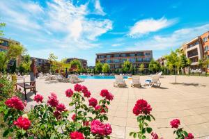 a courtyard with flowers and a swimming pool at Holiday Garden Resort in Sunny Beach