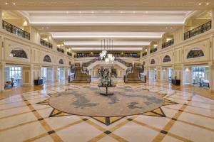 eine große Lobby mit einem Kronleuchter und einem großen Teppich in der Unterkunft Waldorf Astoria Ras Al Khaimah in Ras al Khaimah