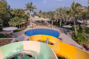 um resort com piscina e palmeiras em Waldorf Astoria Ras Al Khaimah em Ras al-Khaimah