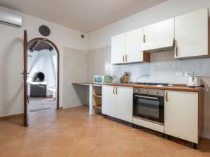 uma cozinha com armários brancos e uma bancada em Sardinian Seaside Bliss em Santa Luria