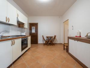 uma cozinha com armários brancos e piso em azulejo em Sardinian Seaside Bliss em Santa Luria