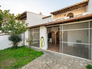 uma casa com portas de vidro deslizantes e um pátio em Sardinian Seaside Bliss em Santa Luria