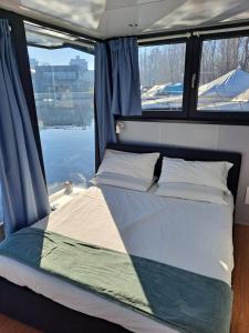 a bed in the back of a boat with two windows at Floating Experience Black Pearl, Lago Maggiore in Dormelletto