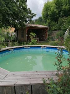 a swimming pool in front of a house at MARIAC , Chambres d'hôtes "AU TILLEUL" 6km du Cheylard in Mariac