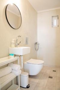 y baño con lavabo, aseo y espejo. en Kineta Seaside Summer Apartments en Kineta