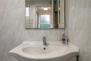 a white sink in a bathroom with a mirror at Cheerful 2 bedroom cottage with garden in Llanelltyd +26 photos