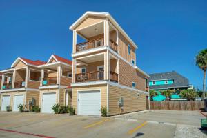 un grand immeuble d'appartements avec un parking dans l'établissement Tipsy Starfish by AvantStay Walk to Beach Pool, à Port Aransas