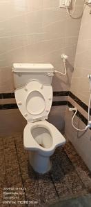 - une salle de bains avec des toilettes blanches dans une cabine dans l'établissement Om Bungalow, à Dwarka