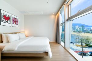 a bedroom with a bed and a large window at Gray 193 Hotel in Busan