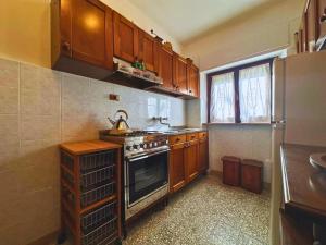 cocina con armarios de madera y horno con fogones en Appartamento Il Fiocco by Nicola Real Estate, en Lucca