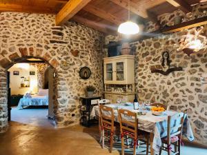 Il Pajarone في مارينا بورتو: غرفة طعام مع طاولة وجدار حجري