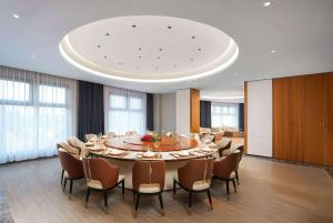 een grote vergaderzaal met een grote tafel en stoelen bij Howard Johnson by Wyndham Huaqiao Plaza Xinyu in Xinyu