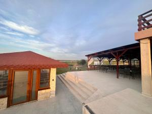 eine Terrasse mit Tischen und Stühlen auf einem Gebäude in der Unterkunft Pensiunea Fabian in Jurilovca