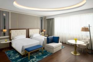 a hotel room with two beds and a chair at Grand Hyatt Al Khobar Hotel and Residences in Al Khobar