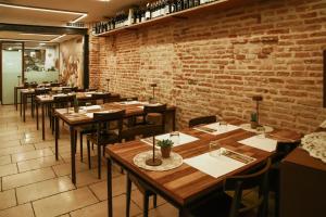 a restaurant with wooden tables and chairs and a brick wall at Locanda Ponte Dante in Treviso