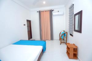 a bedroom with a bed and a chair in it at Hide Hiriketiya Villa in Dickwella
