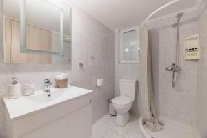 a bathroom with a toilet and a sink and a shower at The HostMaster Beachside Retreat in Vari +19 photos